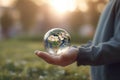 Childs hands holding transparent earth globe over blurred background. Generative AI Royalty Free Stock Photo