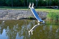 childs slide mirroring in calm water at beach