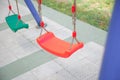 Plastic and Empty red and green chain swings in children playground. chain swings hanging in garden . Childs swing in a park Royalty Free Stock Photo