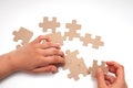 A childs tanned hand collects a blank puzzle on a white background