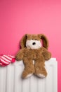 Childs teddy bear and gloves on a bedroom radiator