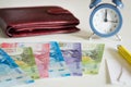 Chile currency, pesos, next to the wallet and the clock showing five to twelve Royalty Free Stock Photo