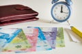 Chile currency, pesos, next to the wallet and the clock showing five to twelve Royalty Free Stock Photo