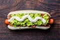 Chilean Completo Italiano. Hot dog sandwiches with tomato, avocado and mayonnaise on wooden board. Top view, copy space