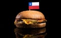Chilean flag on top of hamburger isolated on black Royalty Free Stock Photo