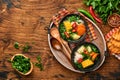 Chilean meat soup with pampkin, corn, fresh coriander and potatoes on old wooden table background. Cazuela. Latinamerican food.