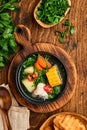 Chilean meat soup with pampkin, corn, fresh coriander and potatoes on old wooden table background. Cazuela. Latinamerican food. Royalty Free Stock Photo