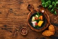 Chilean meat soup with pampkin, corn, fresh coriander and potatoes on old wooden table background. Cazuela. Latinamerican food