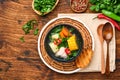 Chilean meat soup with pampkin, corn, fresh coriander and potatoes on old wooden table background. Cazuela. Latinamerican food