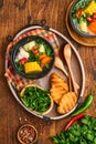 Chilean meat soup with pampkin, corn, fresh coriander and potatoes on old wooden table background. Cazuela. Latinamerican food