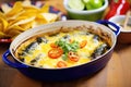 chiles rellenos in a casserole dish with melting cheese