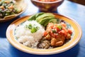 chiles rellenos served with rice and beans on a plate