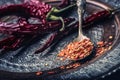 Chili. Chili peppers. Several dried chilli peppers and crushed peppers on an old spoon spilled around. Mexican ingredients Royalty Free Stock Photo