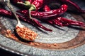 Chili. Chili peppers. Several dried chilli peppers and crushed peppers on an old spoon spilled around. Mexican ingredients Royalty Free Stock Photo