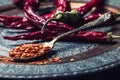 Chili. Chili peppers. Several dried chilli peppers and crushed peppers on an old spoon spilled around. Mexican ingredients Royalty Free Stock Photo