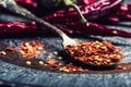 Chili. Chili peppers. Several dried chilli peppers and crushed peppers on an old spoon spilled around. Mexican ingredients Royalty Free Stock Photo