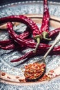 Chili. Chili peppers. Several dried chilli peppers and crushed peppers on an old spoon spilled around. Mexican ingredients Royalty Free Stock Photo