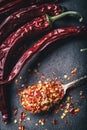 Chili. Chili peppers. Several dried chilli peppers and crushed peppers on an old spoon spilled around. Mexican ingredients Royalty Free Stock Photo