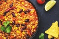 Chili con carne with beef, red beans, paprika, sweet corn and hot peppers in tomato sauce, spicy tex-mex dish in frying pan, black Royalty Free Stock Photo