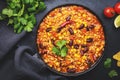 Chili con carne with beef, red beans, paprika, sweet corn and hot peppers in tomato sauce, spicy tex-mex dish in frying pan, black Royalty Free Stock Photo