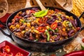 Chili con carne in a clay bowl on a concrete or stone rustic background- traditional dish of mexican cuisine.Top view Royalty Free Stock Photo