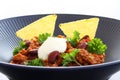 Chili con carne meal in a rustic bowl. Traditional dish of mexican cuisine with kidney beans, minced meat, parsley, tortilla chips Royalty Free Stock Photo