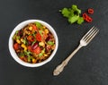 Chili con carne in a white ceramic bowl on black stone background. Cooked with ground beef, tomatoes, peppers, beans, corn, garlic Royalty Free Stock Photo