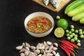 Chili paste thai language Nam prik kapi in a white bowl with ingredients and Fried steam mackerel on the table