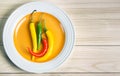 Chili pepper on plate on wooden background. Royalty Free Stock Photo