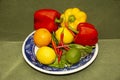 Chilli Peppers Red and yeiiow peppers,lime,lemons, orange on a blue plate Royalty Free Stock Photo