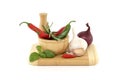 Chili peppers in wooden mortar and herbs over white Royalty Free Stock Photo