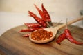 chili powder and dry chili peppers on wooden background. Royalty Free Stock Photo