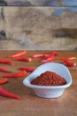 Chili powder and fresh peppers on old wood table Royalty Free Stock Photo