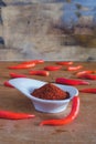 Chili powder and fresh peppers on old wood table Royalty Free Stock Photo