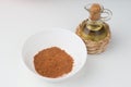 Chili powder in white bowl on white background with olive oil Royalty Free Stock Photo