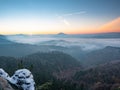 Chill morning with snow on rocky edge, valley full colorful mist Royalty Free Stock Photo