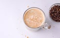 Chilled coffee with cream next to coffee beans