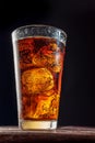 Chilled glass of cola drink with ice cubes isolated on dark background Royalty Free Stock Photo