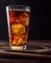 Chilled glass of cola drink with ice cubes isolated on dark background Royalty Free Stock Photo