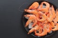 Chilled shrimp in a plate with ice on a dark background