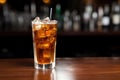 chilled soda with ice and a straw in a clear tall glass