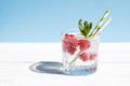 Chilled soda, water, cocktail with fresh berries and mint in a glass on a pastel background. Summer refreshing drinks concept.