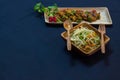 Chilli chicken and noodles served on wooden plates with spoon and fork. delicious chinese food for copy space background