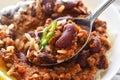 Chilli con carne with rice on spoon in a white bowl. Royalty Free Stock Photo