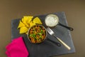 Chilli con carne with scattered parsley, served with soured cream and tortilla chips, red napkin on slate Royalty Free Stock Photo