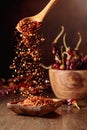 Chilli flakes are poured into a wooden dish