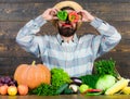 Chilli and sweet pepper as smile and eyes. Bearded farmer hold peppers in front of face. Pepper harvest concept. Farmer