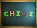 Chilli wooden word on black board