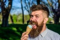 Chilling concept. Man with long beard licks ice cream, close up. Bearded man with ice cream cone. Man with beard and Royalty Free Stock Photo