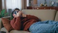 Chilling guy calling smartphone lying on home sofa close up. Smiling man talking Royalty Free Stock Photo